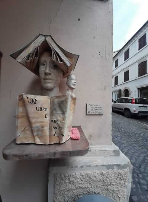 Scultura di un viso con un libro